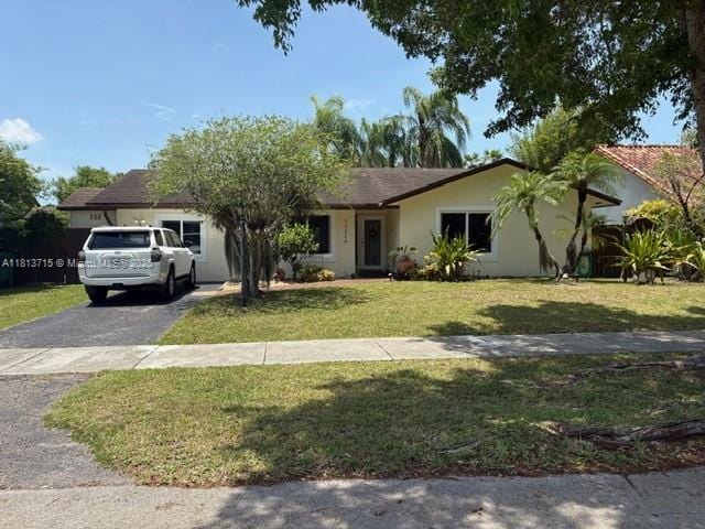 13324 SW 100th Ter, Miami, FL 33186 - ranch-style home with driveway, a front lawn, and stucco siding