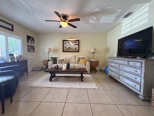 13324 SW 100th Ter, Miami, FL 33186 - living room featuring ceiling fan, a textured ceiling, and light tile patterned flooring