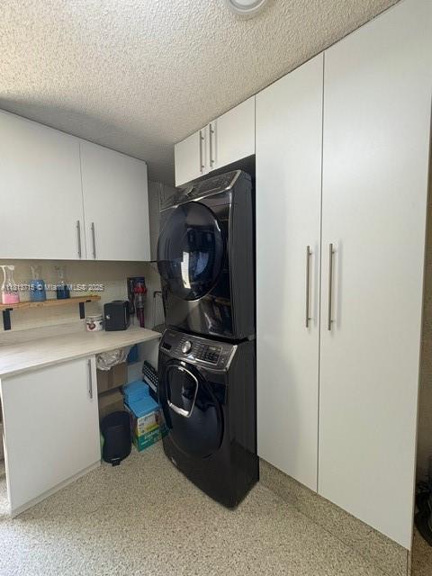 13324 SW 100th Ter, Miami, FL 33186 - washroom with stacked washer / dryer, cabinet space, a textured ceiling, and an office area