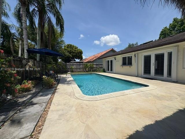 13324 SW 100th Ter, Miami, FL 33186 - view of swimming pool featuring french doors, a patio, and a fenced backyard