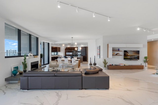 18555 Collins Ave Unit 1703, Sunny Isles Beach, FL 33160 - living area featuring light marble finish floors, rail lighting, a fireplace, and a chandelier