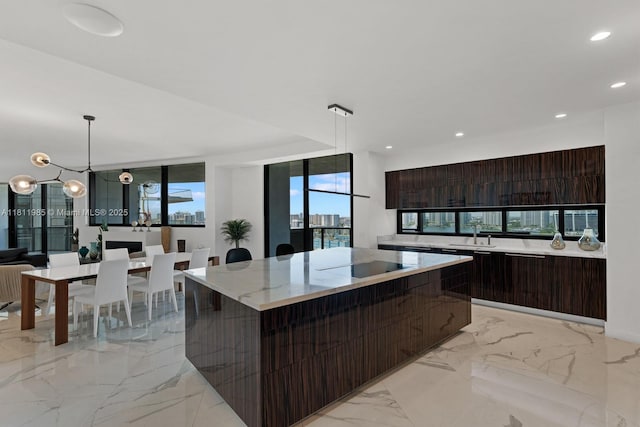18555 Collins Ave Unit 1703, Sunny Isles Beach, FL 33160 - kitchen with modern cabinets, light marble finish flooring, dark brown cabinetry, a large island, and a sink