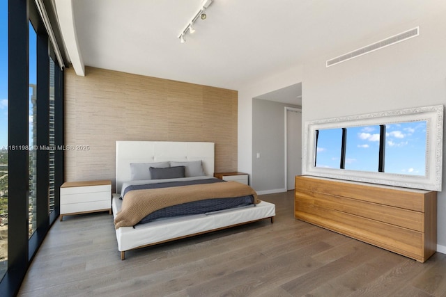 18555 Collins Ave Unit 1703, Sunny Isles Beach, FL 33160 - bedroom with track lighting, multiple windows, wood finished floors, and baseboards