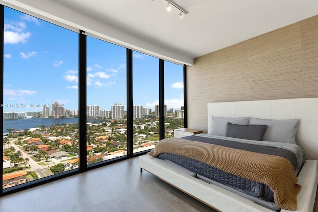 18555 Collins Ave Unit 1703, Sunny Isles Beach, FL 33160 - bedroom with a wall of windows, a view of skyline, multiple windows, track lighting, and wood finished floors