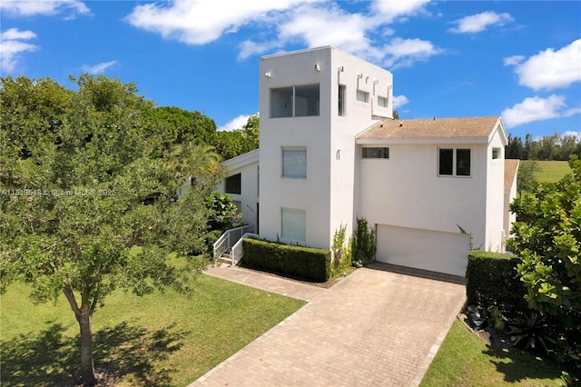 6320 Dolphin Dr, Coral Gables, FL 33158 - view of front of house featuring stucco siding, decorative driveway, a garage, and a front yard