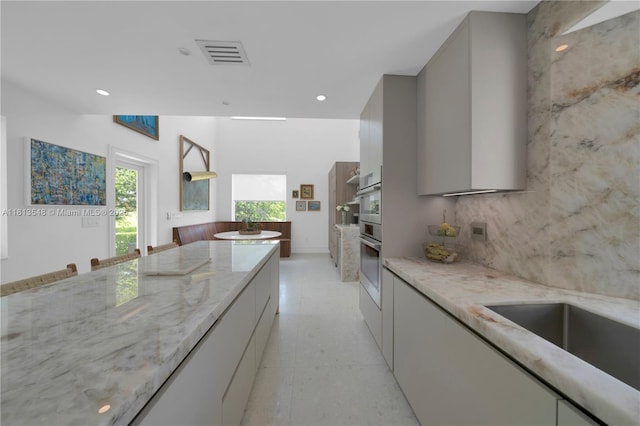 6320 Dolphin Dr, Coral Gables, FL 33158 - kitchen featuring modern cabinets, gray cabinetry, light stone counters, stainless steel oven, and recessed lighting
