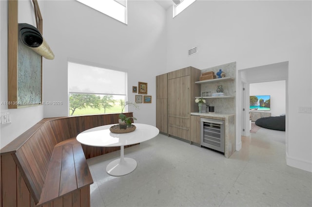 6320 Dolphin Dr, Coral Gables, FL 33158 - dining area with wine cooler, breakfast area, a towering ceiling, and a dry bar