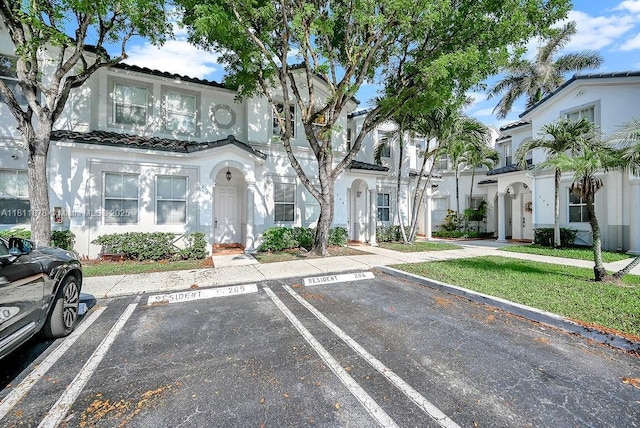 5440NW 107th Ave Unit 204, Doral, FL 33178 - view of front of house featuring uncovered parking, stucco siding, and a tiled roof