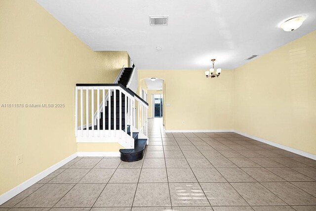 5440NW 107th Ave Unit 204, Doral, FL 33178 - tiled empty room with arched walkways, a chandelier, stairway, and baseboards