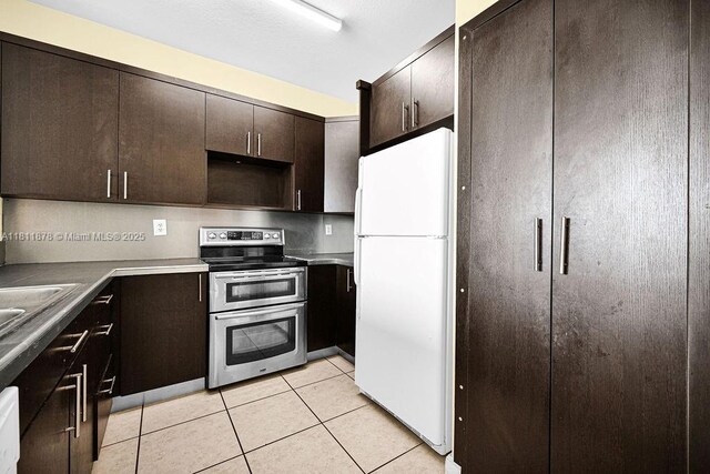 5440NW 107th Ave Unit 204, Doral, FL 33178 - kitchen with freestanding refrigerator, double oven range, light tile patterned floors, dark brown cabinets, and a sink