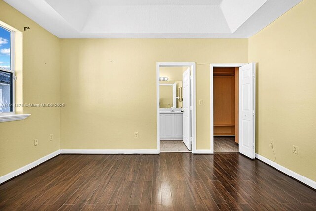 5440NW 107th Ave Unit 204, Doral, FL 33178 - unfurnished bedroom with a tray ceiling, wood finished floors, and baseboards
