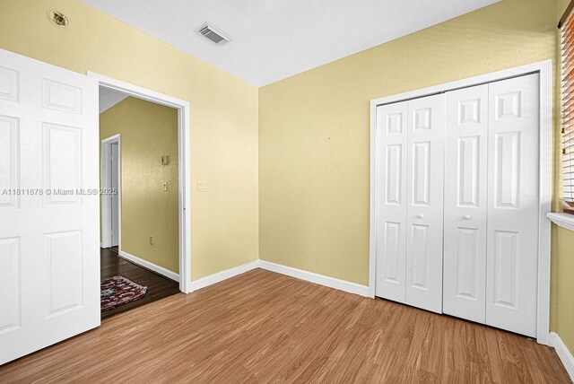 5440NW 107th Ave Unit 204, Doral, FL 33178 - unfurnished bedroom featuring wood finished floors, baseboards, and a closet