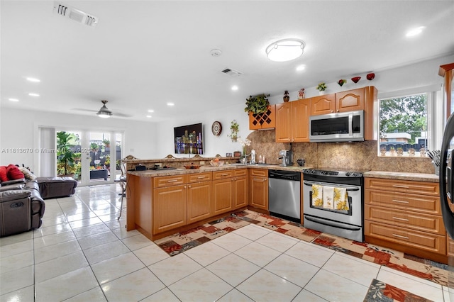 401 SW 109th Ave Unit 26, Sweetwater, FL 33174 - kitchen featuring appliances with stainless steel finishes, a peninsula, open floor plan, decorative backsplash, and a ceiling fan