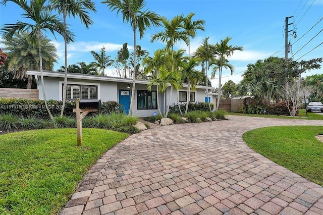 928 NE 18th Ct, Fort Lauderdale, FL 33305 - ranch-style house with curved driveway and stucco siding