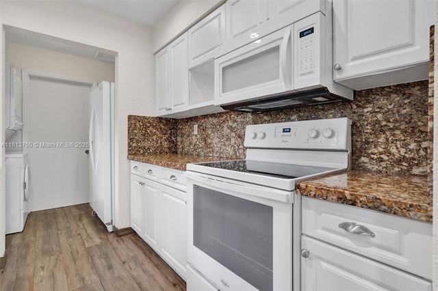 928 NE 18th Ct, Fort Lauderdale, FL 33305 - kitchen with white appliances, washer / dryer, white cabinetry, and backsplash