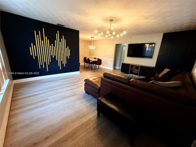 2430 N 61st Ter, Hollywood, FL 33024 - living room with a chandelier, wood finished floors, baseboards, and a textured ceiling