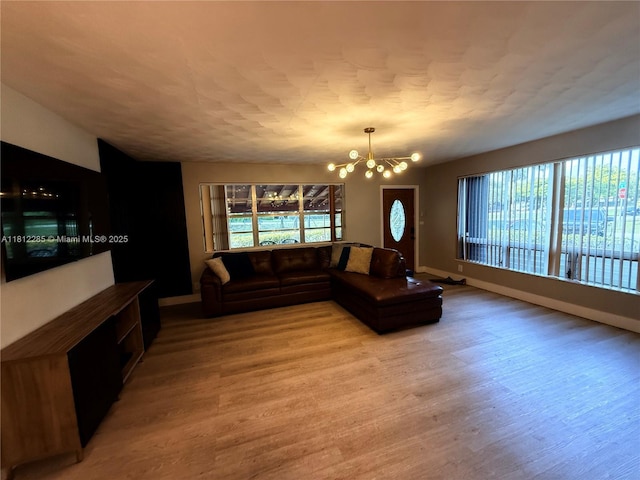 2430 N 61st Ter, Hollywood, FL 33024 - unfurnished living room with a chandelier, light wood-style flooring, and baseboards