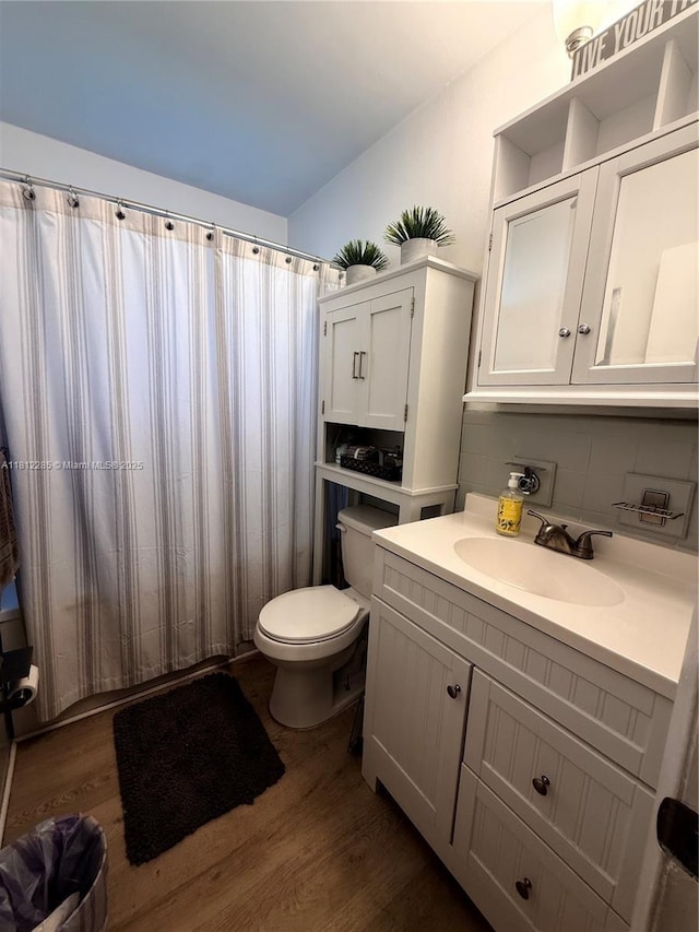 2430 N 61st Ter, Hollywood, FL 33024 - bathroom featuring toilet, wood finished floors, vanity, and tasteful backsplash