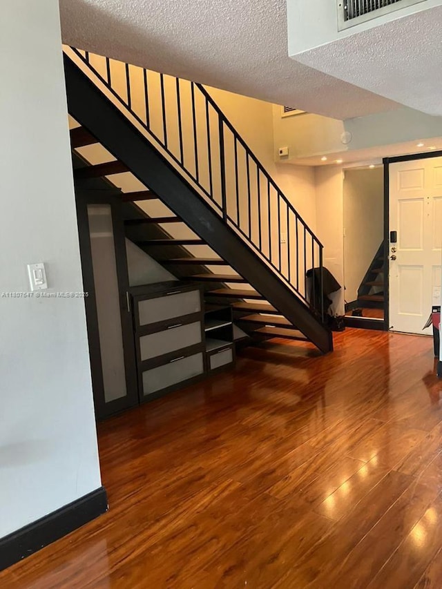 9351 Fontainebleau Blvd Unit B206, Miami, FL 33172 - staircase featuring wood finished floors, baseboards, and a textured ceiling