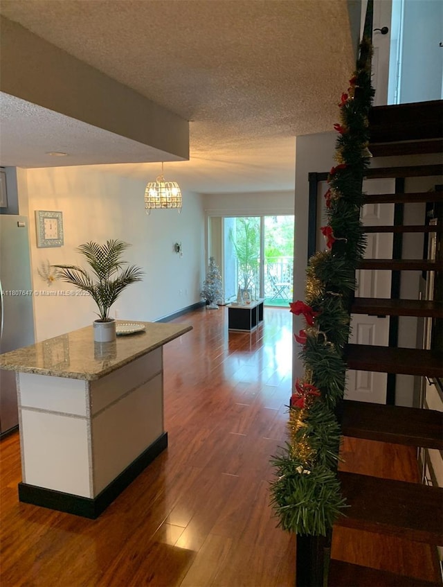 9351 Fontainebleau Blvd Unit B206, Miami, FL 33172 - corridor featuring a textured ceiling, wood finished floors, baseboards, and a chandelier