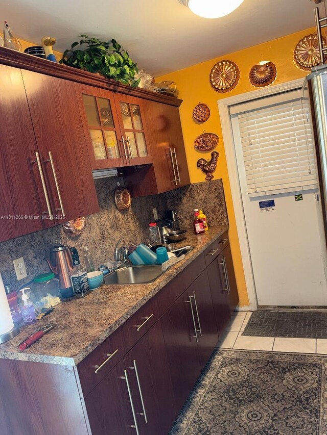 20420 NW 24th Ct, Miami Gardens, FL 33056 - kitchen with decorative backsplash, light tile patterned floors, glass insert cabinets, and a sink