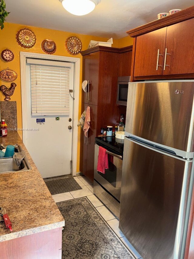 20420 NW 24th Ct, Miami Gardens, FL 33056 - kitchen with appliances with stainless steel finishes, a sink, light tile patterned floors, and light countertops