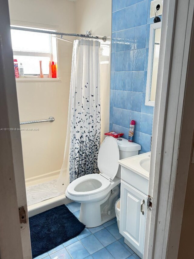20420 NW 24th Ct, Miami Gardens, FL 33056 - full bathroom featuring toilet, tile patterned flooring, vanity, a stall shower, and tile walls