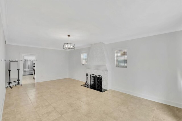 276 NE 90th St, El Portal, FL 33138 - unfurnished living room featuring a chandelier, a large fireplace, baseboards, and crown molding
