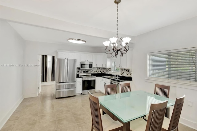 276 NE 90th St, El Portal, FL 33138 - kitchen featuring appliances with stainless steel finishes, backsplash, a chandelier, a sink, and dark countertops