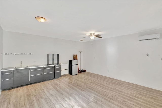 276 NE 90th St, El Portal, FL 33138 - unfurnished room with a wall unit AC, a ceiling fan, light wood-style floors, a sink, and baseboards