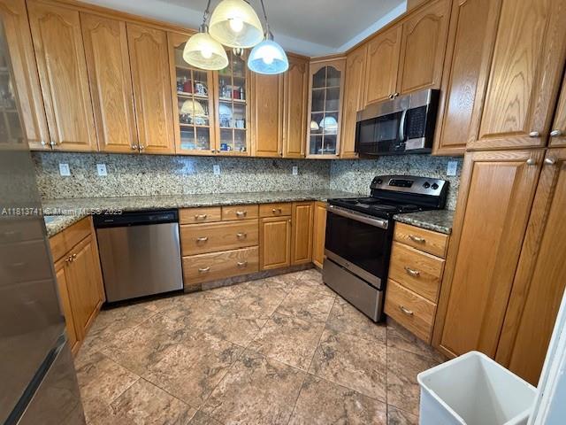 1525 SW 18th St, Miami, FL 33145 - kitchen with stainless steel appliances, decorative backsplash, hanging light fixtures, glass insert cabinets, and stone countertops
