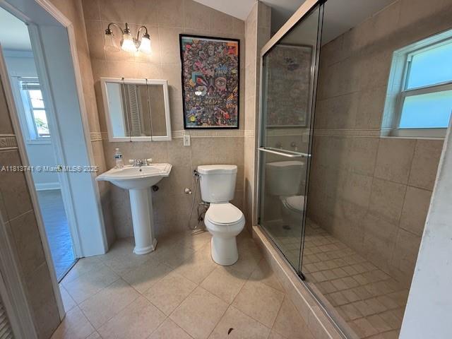 1525 SW 18th St, Miami, FL 33145 - full bathroom featuring tile walls, a stall shower, tile patterned flooring, and vaulted ceiling