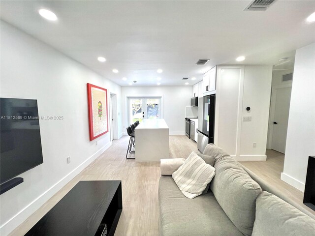 1451 NE 155th Ter, North Miami Beach, FL 33162 - living area with light wood finished floors, recessed lighting, and baseboards