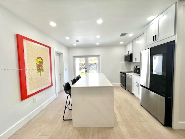 1451 NE 155th Ter, North Miami Beach, FL 33162 - kitchen with smart refrigerator, range, white cabinetry, light countertops, and recessed lighting