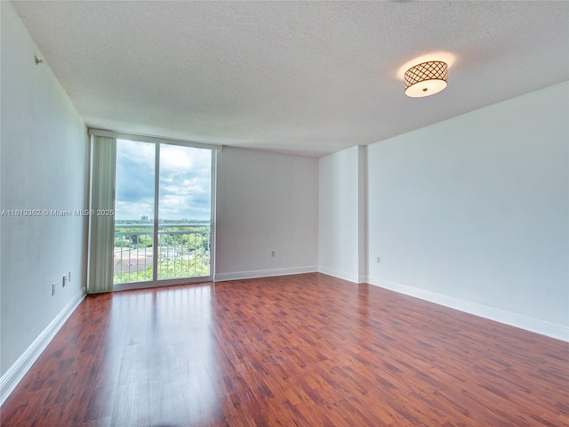 3000 Coral Way Unit 715, Miami, FL 33145 - empty room with plenty of natural light, floor to ceiling windows, dark wood-type flooring, and a textured ceiling
