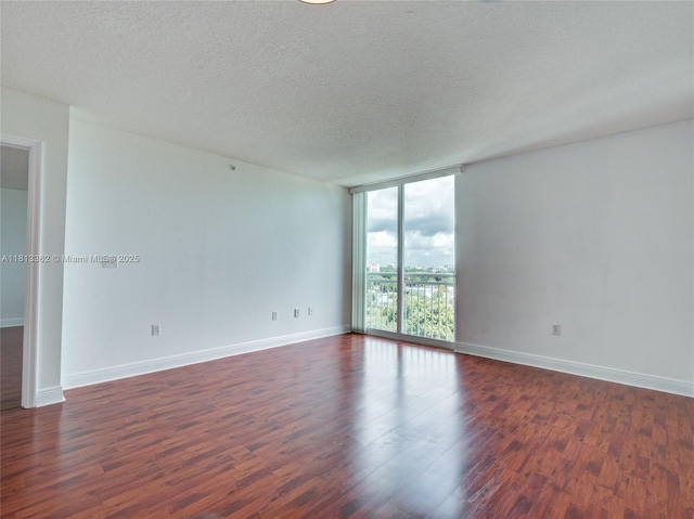 3000 Coral Way Unit 715, Miami, FL 33145 - empty room featuring dark wood-style flooring, a wall of windows, and a textured ceiling