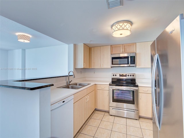 3000 Coral Way Unit 715, Miami, FL 33145 - kitchen with stainless steel appliances, light brown cabinetry, light tile patterned floors, and a peninsula