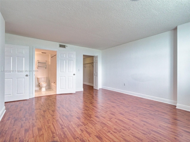 3000 Coral Way Unit 715, Miami, FL 33145 - unfurnished bedroom featuring wood finished floors, a textured ceiling, ensuite bath, a spacious closet, and a closet