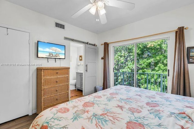 140 Aregood Ln Unit C2, Plantation Key, FL 33036 - bedroom featuring a barn door, wood finished floors, ceiling fan, and connected bathroom