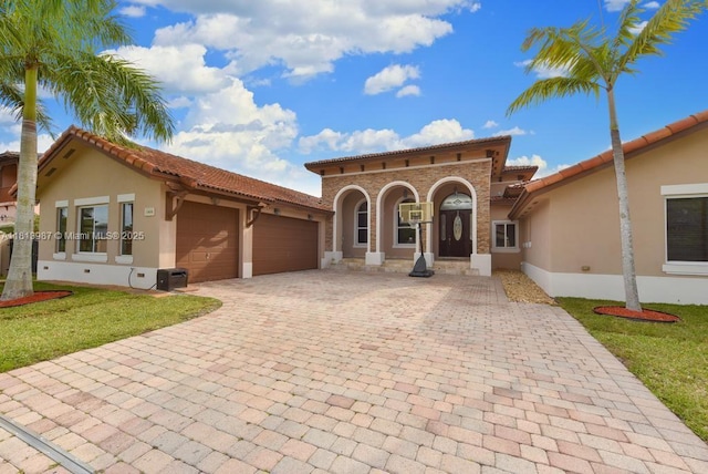 19686 SW 130th Ave Rd, Miami, FL 33177 - mediterranean / spanish-style home with decorative driveway, stucco siding, a garage, a tile roof, and a front lawn