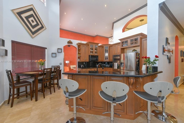 19686 SW 130th Ave Rd, Miami, FL 33177 - kitchen with appliances with stainless steel finishes, brown cabinets, a towering ceiling, a sink, and a peninsula