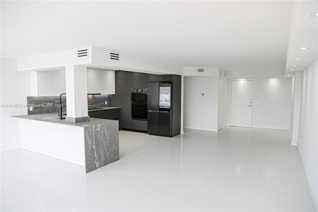 200 Leslie Dr Unit 314, Hallandale Beach, FL 33009 - kitchen featuring modern cabinets, decorative backsplash, multiple ovens, light tile patterned flooring, and a peninsula