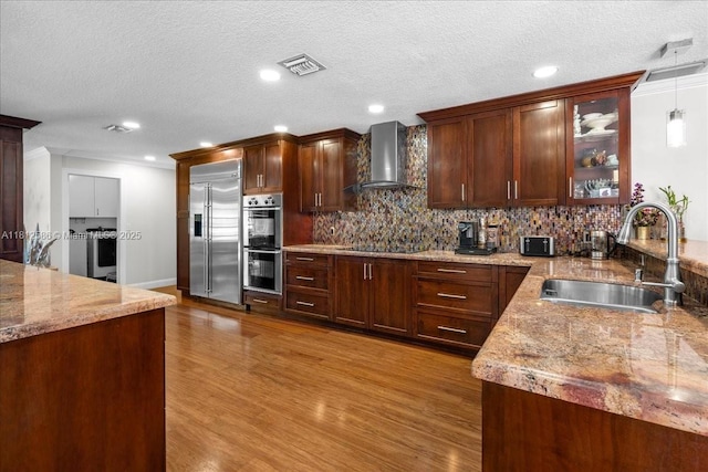 3030 SW 117th Ave, Davie, FL 33330 - kitchen with wall chimney exhaust hood, stainless steel appliances, a sink, wood finished floors, and tasteful backsplash