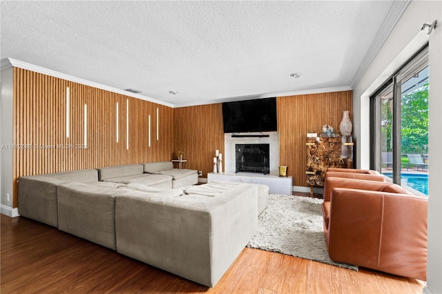 3030 SW 117th Ave, Davie, FL 33330 - living room featuring crown molding, a textured ceiling, wood finished floors, a fireplace, and wooden walls