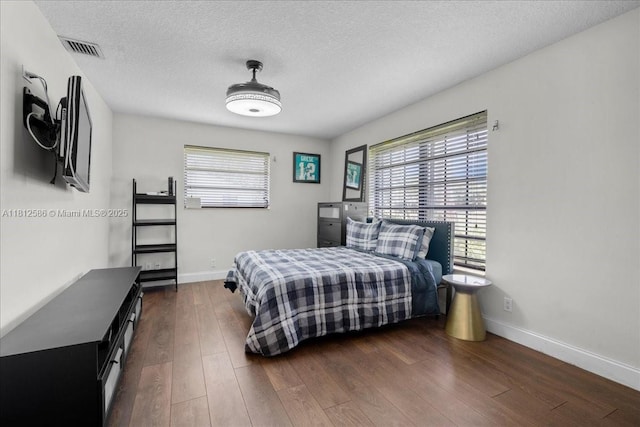3030 SW 117th Ave, Davie, FL 33330 - bedroom with multiple windows, wood finished floors, baseboards, and a textured ceiling