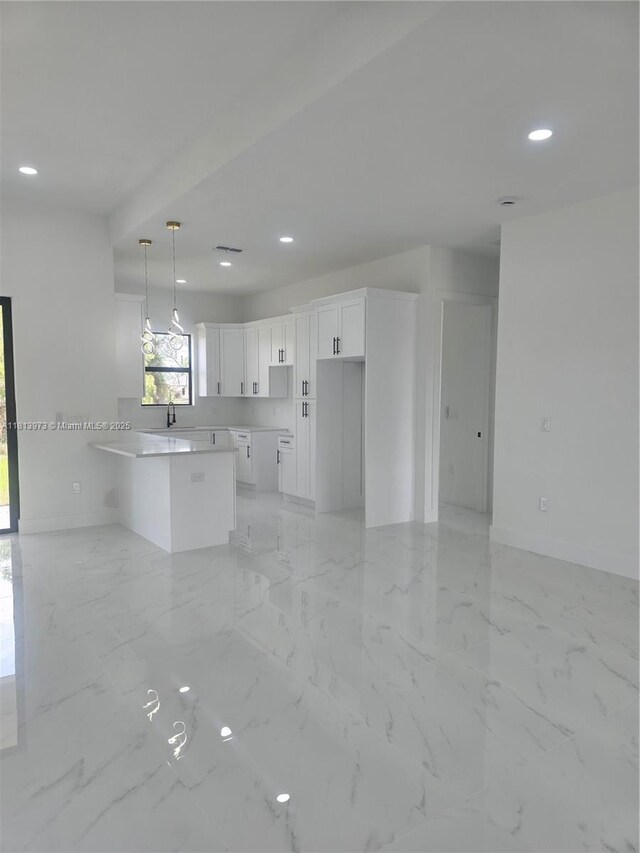 987 Edgerton, Lehigh Acres, FL 33974 - kitchen featuring a peninsula, white cabinetry, baseboards, light marble finish flooring, and recessed lighting
