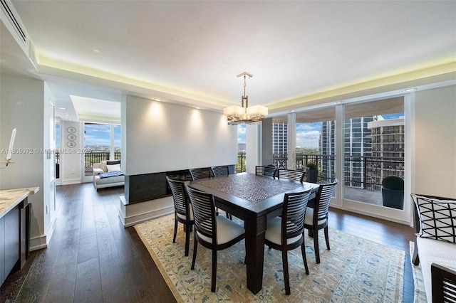 2901 S Bayshore Dr Unit 17G/H, Miami, FL 33133 - dining space featuring plenty of natural light, a chandelier, dark wood-type flooring, and a tray ceiling