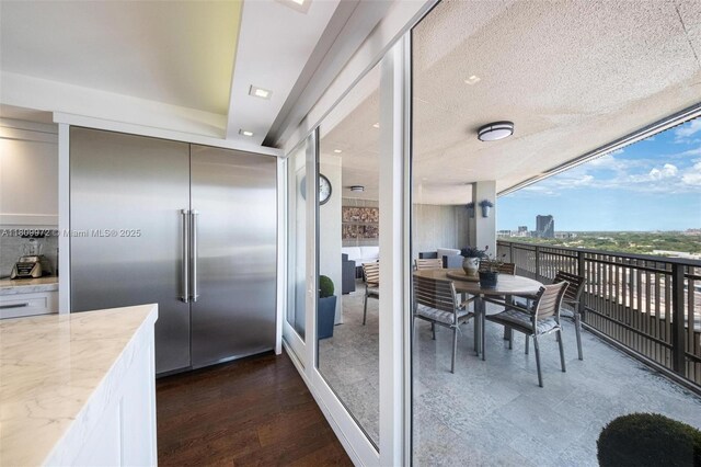 2901 S Bayshore Dr Unit 17G/H, Miami, FL 33133 - kitchen featuring stainless steel built in fridge, light stone countertops, white cabinets, and dark wood-type flooring