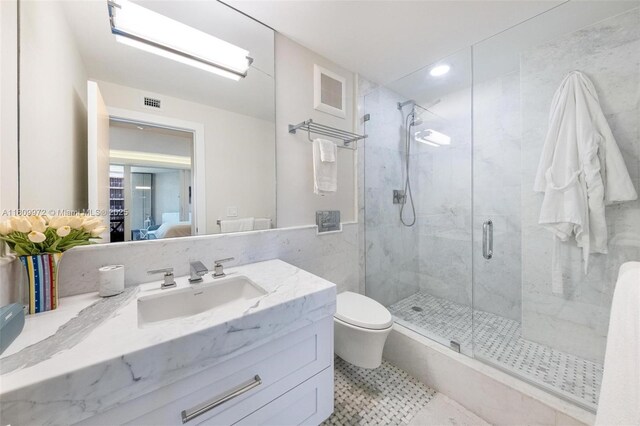 2901 S Bayshore Dr Unit 17G/H, Miami, FL 33133 - ensuite bathroom featuring a marble finish shower, vanity, tile walls, toilet, and recessed lighting