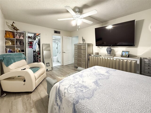700 Lori Dr Unit 201, Palm Springs, FL 33461 - bedroom featuring light wood-style floors, a textured ceiling, ceiling fan, ensuite bath, and a spacious closet